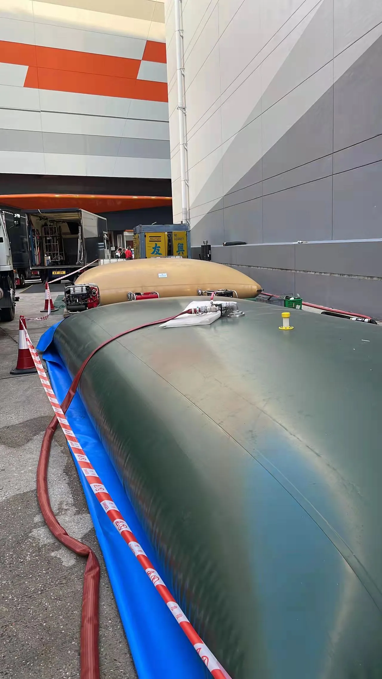 Flexible bladder tanks deployed beside an industrial facility